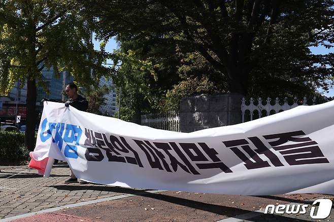 국민의힘 관계자가 20일 서울 여의도 국회 앞에서 이재명 더불어민주당 대표를 향한 정쟁형 현수막을 철거한 후 '국민의 뜻대로 민생 속으로'라는 현수막을 달고 있다. 2023.10.20/뉴스1 ⓒ News1 신웅수 기자