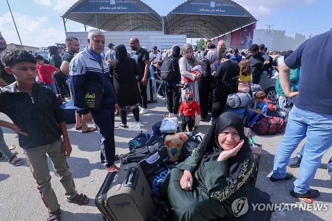 이집트 국경 검문소 앞 대기하는 팔레스타인 피란민들. 사진=연합뉴스