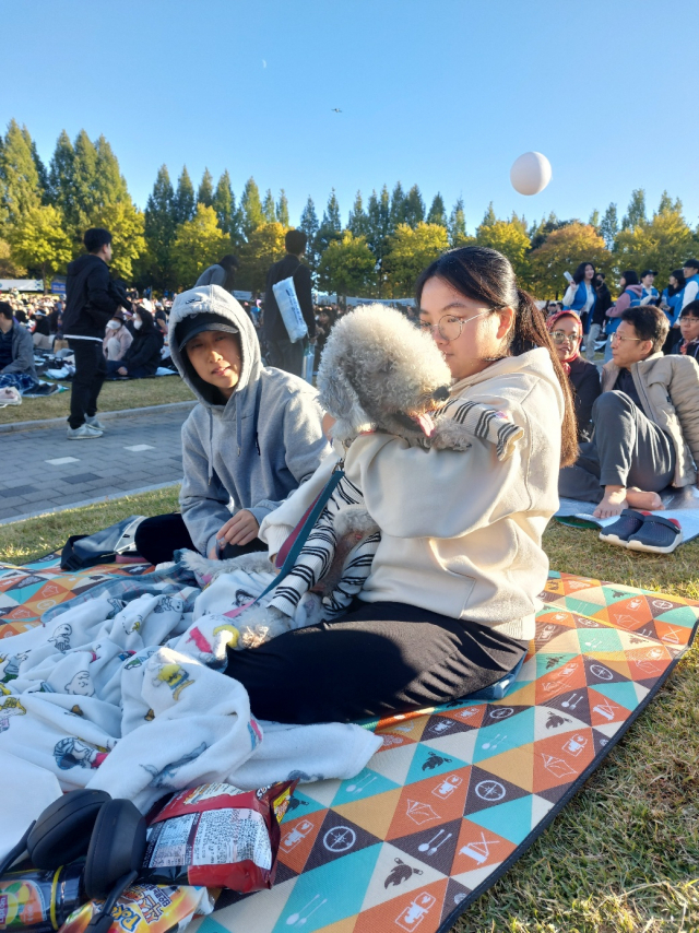 반려견을 안고 맞손토크를 즐기는 모자. 사진 = 손대선 기자