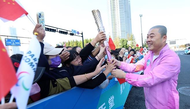 항저우장애인아시아경기 김진혁 한국선수단장이 21일 성화봉송을 마친 뒤 중국 사람들과 인사하고 있다. 대한장애인체육회 제공