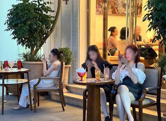 짱띠엔 거리의 한 노천카페에서 만난 젊은이들이 스마트폰을 보고 있다. /김은영 기자