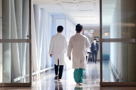 Doctors walk across a corridor at a hospital in Seoul on Dec. 28, 2022. [NEWS1]