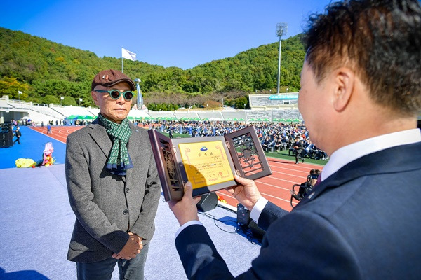 허영만 화백(왼쪽)이 정기명 여수시장으로부터 홍보대사 위촉패를 받고 있다. [여수시 제공]