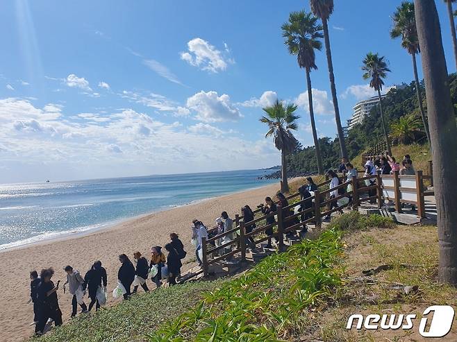 20일 국카스텐 하현우와 사전신청으로 모집한 참가자, 롯데호텔앤리조트 및 제주관광공사 임직원 등 50명이 플로깅을 하고 있다(롯데호텔앤리조트 제공).