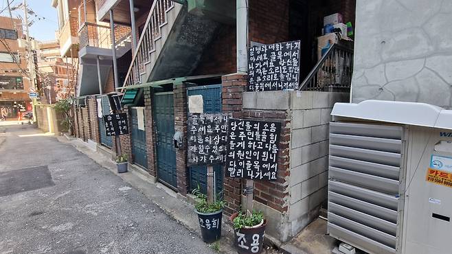 서울 합정동의 한 돈까스집 앞 주택에 붙어 있는 팻말. ‘골목에서 나가세요’라고 적혀 있다. 박지영 기자