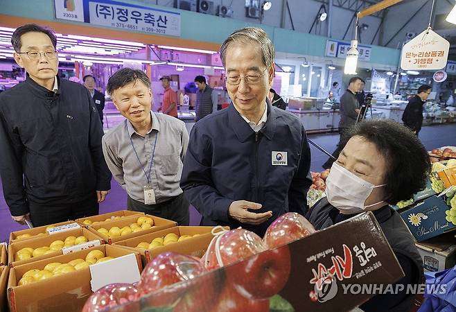 사과 구입하는 한덕수 국무총리 (서울=연합뉴스) 황광모 기자 = 한덕수 국무총리가 24일 오후 농수산물 물가 점검을 위해 서울 마포구 마포농수산물시장을 찾아 과일 가게를 찾아 올해 들어 대폭오른 사과를 구입하며 현장 물가를 점검하고 있다. 2023.10.24 hkmpooh@yna.co.kr