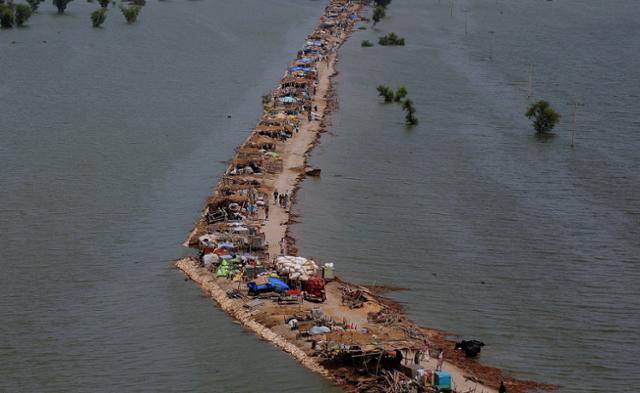 2010년 9월 대홍수가 난 파키스탄 남부 신드주 카이르푸르의 한 지역에서 물에 잠기지 않은 길 위로 난민촌이 아슬아슬하게 형성돼 있다. 카이르푸르=AFP 연합뉴스