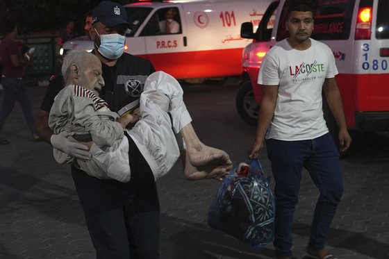 21일(현지시간) 이스라엘 공습으로 다친 팔레스타인 주민이 병원으로 옮겨지고 있다. AP=연합