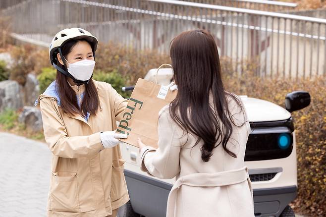 hy 프레시 매니저가 소비자에게 제품을 배달하고 있다.  hy