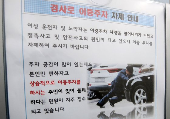 대구시 수성구 매호동 한 아파트 엘리베이터에 붙은 '이중주차 자제 안내문'에 조국 전 법무부 장관이 차량을 밀고 있는 사진이 쓰였다. [SNS 갈무리]