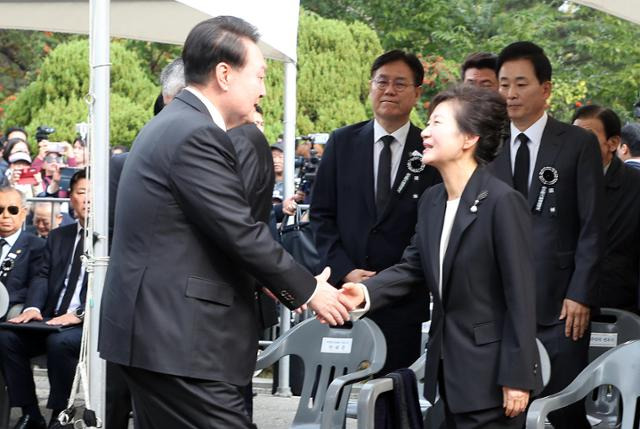 윤석열 대통령이 26일 국립서울현충원에서 열린 박정희 전 대통령 44주기 추도식에서 박근혜 전 대통령과 악수하고 있다. 뉴시스