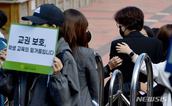 [광주=뉴시스] 류형근 기자 = 초등교사노동조합이 지난 24일 오후 광주 북구 한 초등학교 앞에서 "1년여의 재판끝에 아동학대 무혐의 판결된 교사에 대한 교권회복"을 촉구하고 있는 가운데 학생들이 하교 중에 교사를 위로하고 있다. 2023.10.26. hgryu77@newsis.com