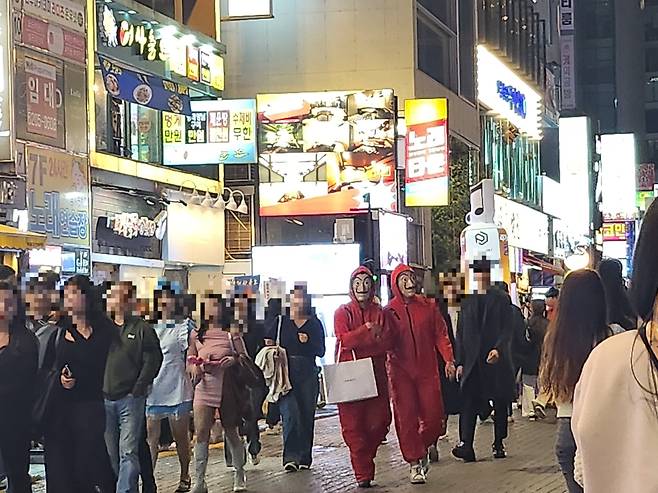 27일 오후 서울 신논현역 7번 출구 앞 핼러윈 데이 분장을 한 사람과 주변을 지나는 시민들. / 오유진 기자