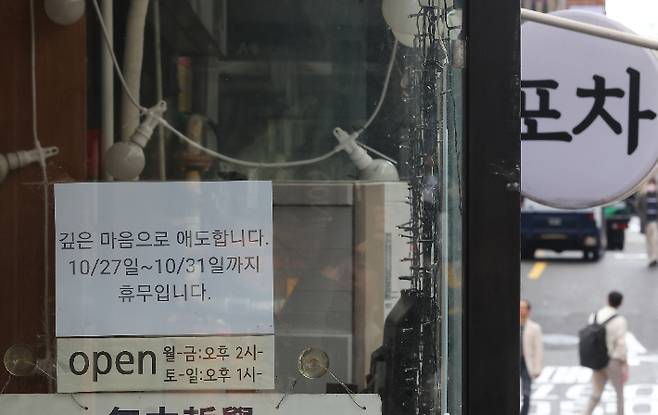 핼러윈 데이를 앞두고 시내 번화가에 인파 밀집이 예상되는 가운데 27일 오후 서울 용산구 이태원 거리 한 상점에 지난해 이태원 참사 희생자 추모 및 휴무 안내문이 붙어 있다. 연합뉴스