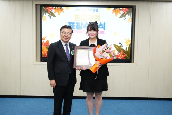 류경기(왼쪽) 서울 중랑구청장이 화재 진압에 공헌한 망우동 어린이집 교사 변지원 씨에게 표창장을 수여한 뒤 기념 촬영을 하고 있다. 중랑구 제공