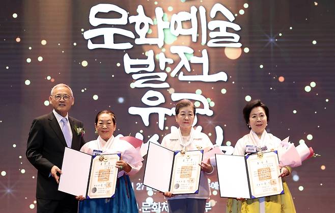 유인촌 문화체육관광부 장관 '문화예술발전 유공 시상식'  (서울=연합뉴스) 유인촌 문화체육관광부 장관이 27일 서울 서대문구 모두예술극장에서 열린 문화예술발전 유공 시상식에 참석해 은관 문화훈장을 전수하고 기념촬영을 하고 있다. [문화체육관광부 제공. 재판매 및 DB 금지]