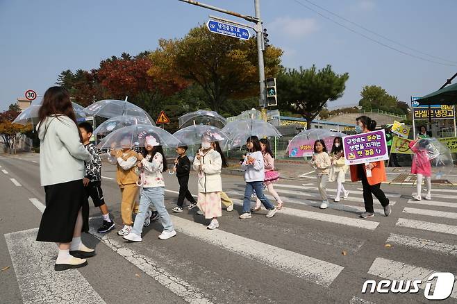 현대제철 당진제철소 임직원을 비롯해 마중물 주부봉사단이 계성초등학교 인근 교차로에서 교통안전 켐페인을 펼치고 있다.(현대제철 제공)/뉴스1