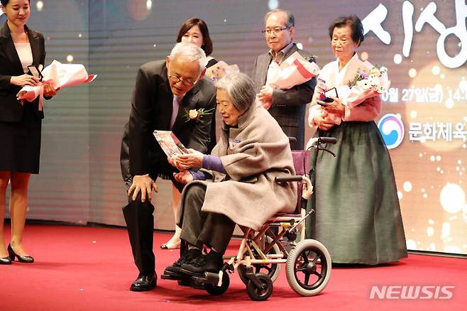 [서울=뉴시스] 박진희 기자 = 가수 양희은·희경의 모친 윤순모 여사가 27일 서울 서대문구 모두예술극장에서 열린 ‘2023년 문화예술발전 유공자‘ 시상식에 참석하여 유인촌 문화체육관광부 장관에게 '예술가의 장한 어버이상(감사패)'을 수여받고 있다. 2023.10.27. pak7130@newsis.com