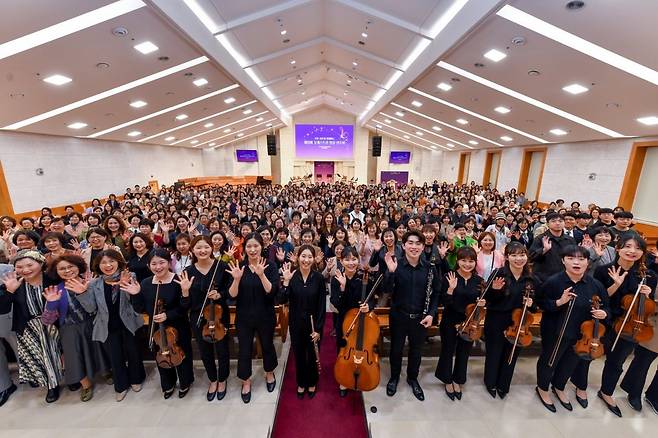 18일 ‘서울동대문 하나님의 교회’에서 열린 연주회에 참석한 관객과 연주자들이 환한 미소와 함께 기념촬영을 하고 있다.