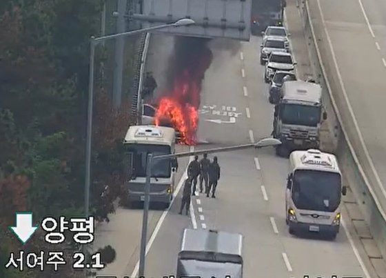 지난달 27일 오전 11시47분쯤 경기 여주시 중부내륙고속도로 양평 방향에서 SUV 차량 엔진룸에서 불이 났다. 이 도로를 지나던 군용 버스에서 군인들이 내려 초기 진화 작업을 하는 모습이다. 사진 경기도소방재난본부