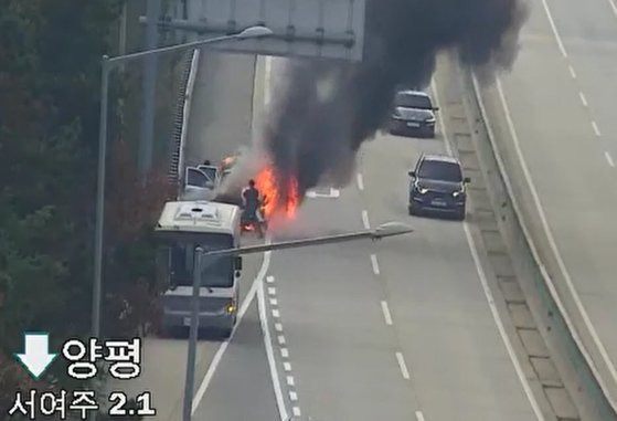 지난달 27일 오전 11시47분쯤 경기 여주시 중부내륙고속도로 양평 방향에서 SUV 차량 엔진룸에서 불이 났다. 이 도로를 지나던 군용 버스에서 군인들이 내려 초기 진화 작업을 하는 모습이다. 사진 경기도소방재난본부