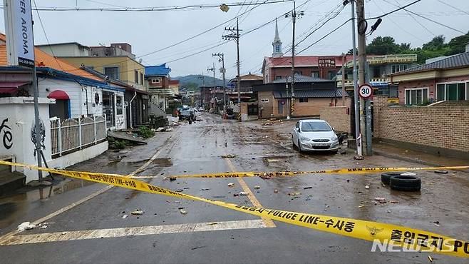 [공주=뉴시스] 송승화 기자 = 지난 7월15일 내린 비로 사망자 1명이 발생한 공주시 옥룡동 수해 현장엔 출입을 금지하는 폴리스 라인이 걸려 있고, 빠져나오지 못한 차량들과 물에 떠내려 온 토사, 생활 쓰레기 등이 도로에 널려 있다. 2023.07.16. ssong1007@newsis.com