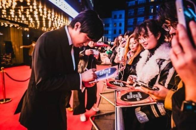 29일 제8회 런던아시아영화제 폐막식이 열린 오데온 레스터 스퀘어 럭스 극장 앞에 마련된 레드카펫 현장. 전날 영화 ‘화란’을 본 관객들이 부슬부슬 내리는 비에도 인파를 형성했다. 배우 홍사빈은 팬들의 사진 촬영 및 사진 요청에 일일이 소년의 미소로 응했다. ⓒ런던아시아영화제 제공