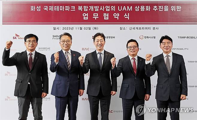 SKT, 화성국제테마파크 UAM 사업 추진 위한 업무협약 체결 (서울=연합뉴스) 2일 서울 강남구 신세계프라퍼티 본사에서 신용식 SK텔레콤 부사장(왼쪽부터), 임영록 신세계프라퍼티 대표이사, 윤형중 한국공항공사 사장, 어성철 한화시스템 대표이사, 이종호 티맵모빌리티 대표이사가 화성국제테마파크 도심항공교통(UAM) 사업 추진을 위한 업무협약(MOU)을 체결 후 기념 촬영하고 있다. 2023.11.2 [SK텔레콤 제공. 재판매 및 DB 금지] photo@yna.co.kr