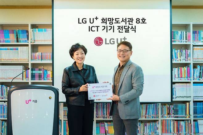 LG유플러스 이철훈 대외전략그룹장(전무, 오른쪽)과 광주세광학교 김선미 교장이 지난달 30일 광주세광학교에서 진행한 U+희망도서관 8호점 지원 기금 및 현판 전달식에서 기념촬영을 하고 있다. LG유플러스 제공