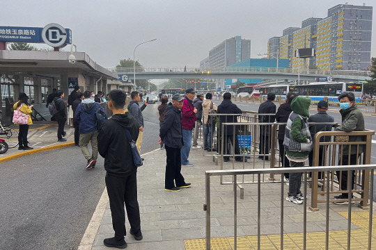 2일 중국 베이징의 한 지하철역 출입구 인근에서 시민들이 리커창 전 총리의 유해 운구행렬을 지켜보기 위해 연단에서 대기하고 있다. AP 연합뉴스