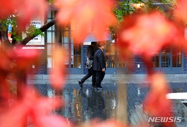 [서울=뉴시스] 배훈식 기자 = 전국에 가을비가 내린 5일 오전 서울 종로구 율곡로에서 우산을 쓴 시민이 곱게 물든 단풍 사이로 걸어가고 있다. 2023.11.05. dahora83@newsis.com