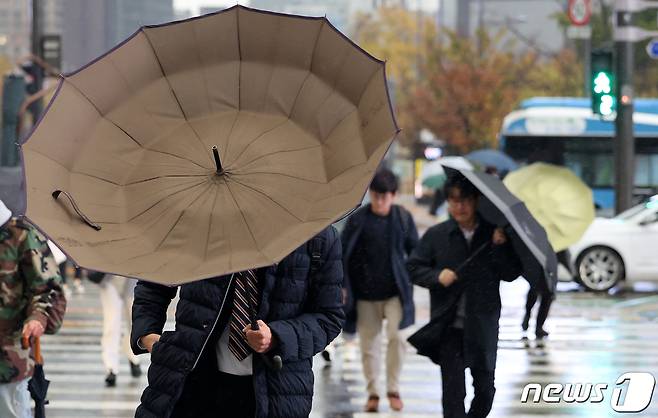 전국에 강풍을 동반한 비가 내린 6일 서울 광화문 네거리에서 우산을 쓴 시민들이 강풍으로 인해 뒤집힌 우산을 부여잡고 있다. 2023.11.6/뉴스1 ⓒ News1 김성진 기자