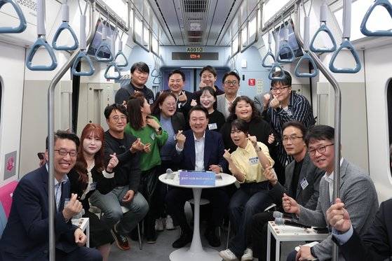 윤석열 대통령이 6일 오후 경기도 화성시 동탄역 GTX-A 열차 내에서 열린 광역교통 국민간담회에서 간담회 참석자들과 기념촬영을 하고 있다. 대통령실사진기자단