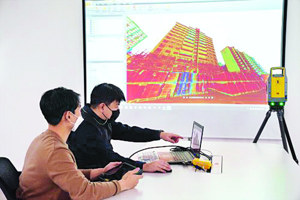롯데건설 직원들이 3D 스캐너를 활용해 기존 아파트 리모델링 데이터를 확인하는 모습. 롯데건설 제공
