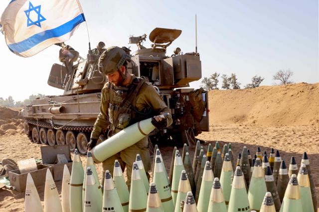 6일 이스라엘군 한 포병이 가자지구와 인접한 남부 지역에서 포탄을 준비하고 있다. AFP 연합뉴스