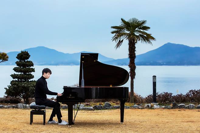 피아니스트 윤한이 가족과 함께 한 달 살기를 한 남해 창선면 서대리의 하얀집 마당에서 자신이 창작한 곡을 연주하고 있다. /영상미디어 양수열 기자