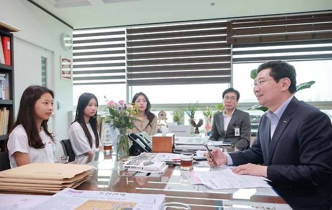 이상일 용인시장이 체육관과 급식시설 신축을 건의하기 위해 시장실을 방문한 역북초등학교 학부모, 학생들과 대화를 나누고 있다. [사진제공=용인시]