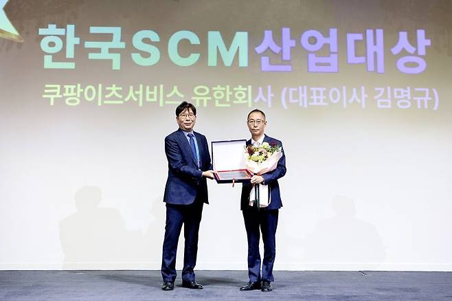 제22회 한국 SCM 산업대상 시상식에서 로지스틱스 부문 대상을 받은 김명규 쿠팡이츠서비스 대표(오른쪽)가 한현수 한국SCM학회 회장과 기념촬영을 하고 있다.