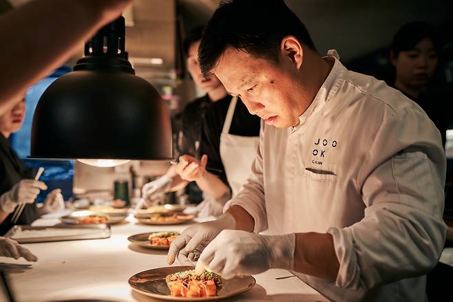 Shin Chang-ho, head chef of Korean contemporary restaurant Joo Ok, prepares a dish during the Korean Food Promotion Institution's "Shape, Share, Start: For Korea Ingredients," an event held in Seoul on Nov. 3. (Korean Food Promotion Institution)