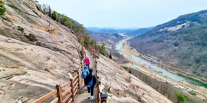 용궐산을 찾은 등산객들이 발아래 펼쳐진 섬진강 풍경을 감상하며 잔도를 걷고 있다. /김영근 기자