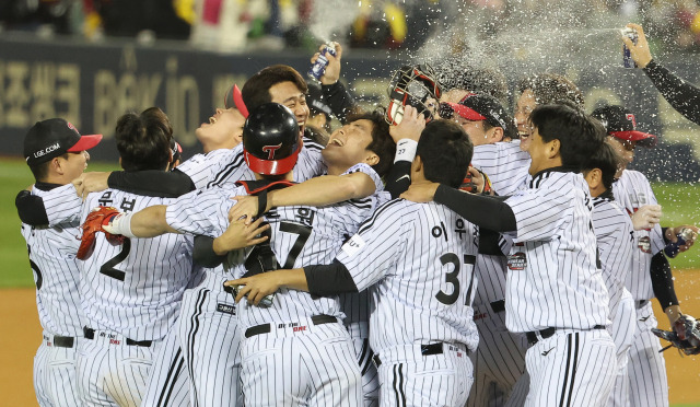 LG 트윈스 선수들이 13일 잠실구장에서 열린 KBO 한국시리즈 5차전에서 KT 위즈를 꺾고 우승을 확정한 뒤 한데 모여 스프레이를 뿌리며 환호하고 있다. 연합뉴스