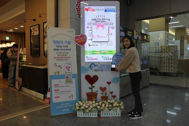 삼성전기 직원이 14일 경기 수원시 본사에서 나눔키오스크 기부에 참여한 뒤 인증 기념촬영하고 있다. 삼성전자 제공