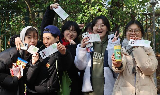 2024학년도 대학수학능력시험을 하루 앞둔 15일 오전 서울 중구 이화여자고등학교에서 3학년 학생들이 취재진을 향해 수험표와 선물을 들어보이며 밝게 웃고 있다. 백소아 기자 thanks@hani.co.kr