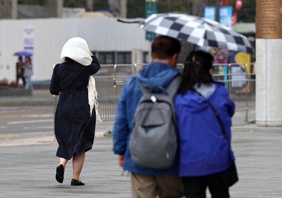3일 오후 서울 광화문광장에서 쓴 시민들이 내리는 비를 피하며 걷고 있다. 뉴스1