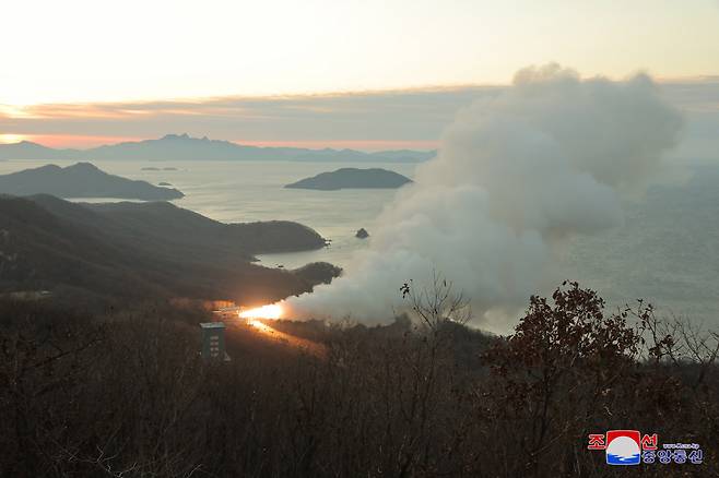 A fire shoots out and smoke rises during a ground jet test of a new type of high-thrust solid engine for intermediate-range ballistic missiles in this undated photo released by North Korea's official Korean Central News Agency KCNA on Wednesday. (Yonhap)