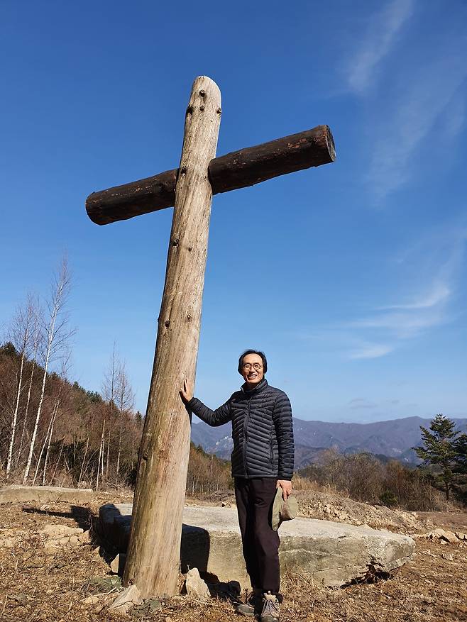 강원 평창 산마루공동체의 대형 나무십자가 앞에 선 이주연 목사. 이 목사는 2019년 5월 이 십자가를 세운 것으로 시작으로 5만평 광야를 기도와 노동 공동체로 일구고 있다. /김한수 기자