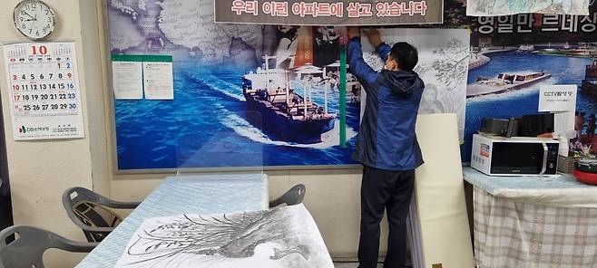 지난 18일 경북 포항 흥해실내체육관 이재민 대피소에서 이재민 김모씨가 지난 4년간 마음을 달래기 위해 취미로 그려온 수묵화를 떼고 있다. 대피소에서 가장 오래 거주했던 김씨는 이곳에서 지진의 아픔을 주제로 50여점의 작품을 그렸다./이승규 기자