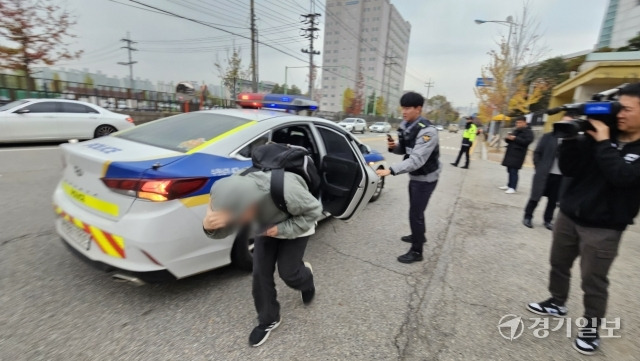 16일 오전 8시5분께 경기도교육청 제30지구 제4시험장 수원 매원고 앞에서 경찰차를 타고 도착한 한 수험생이 얼굴을 가린 채 시험장으로 들어가고 있다. 오민주기자