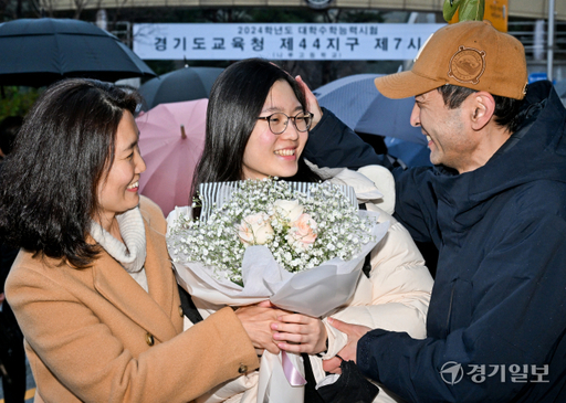 2024학년도 대학수학능력시험일인 16일 오후 화성시 나루고등학교 시험장 앞에서 한 학부모가 수능을 마친 수험생 자녀에게 꽃다발을 건네며 격려하고 있다. 윤원규기자