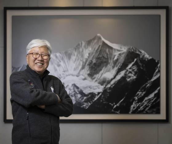 한국 산악계의 대부로 불리는 이인정 아시아산악연맹 회장이 서울 청담동 집무실 입구에 있는 에베레스트 사진 앞에서 활짝 웃고 있다. 김상선 기자